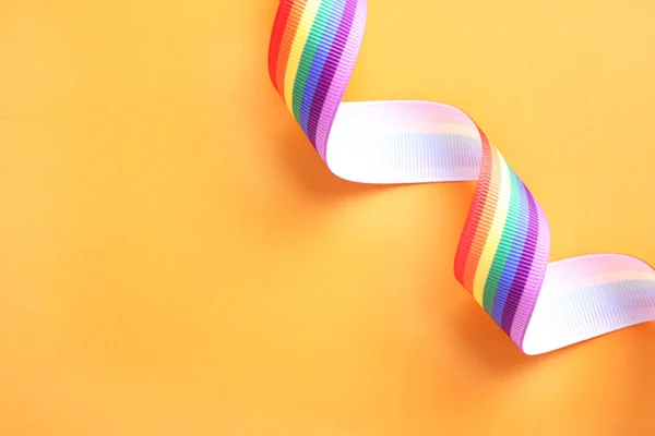 Bright rainbow ribbon on color background, top view with space for text. Symbol of gay community — Stock Photo, Image