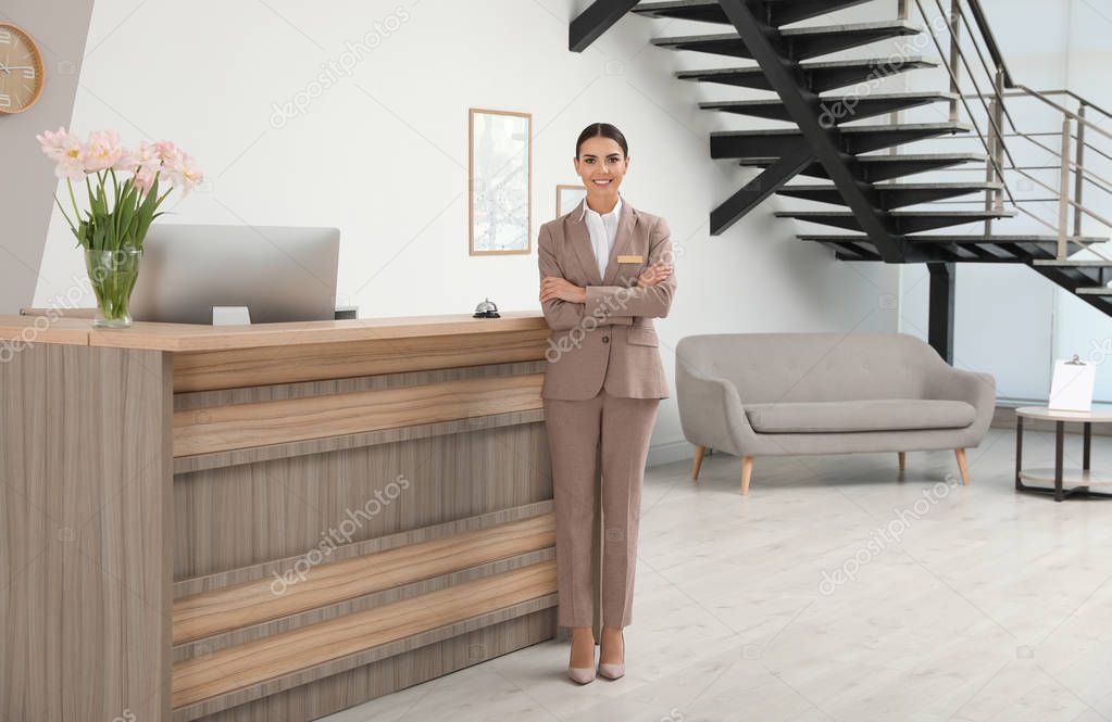 Portrait of receptionist near desk in modern hotel