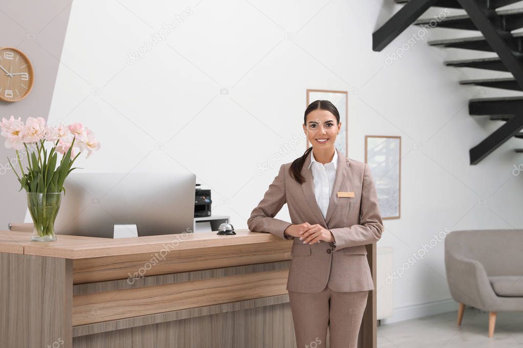 Portrait of receptionist near desk in modern hotel