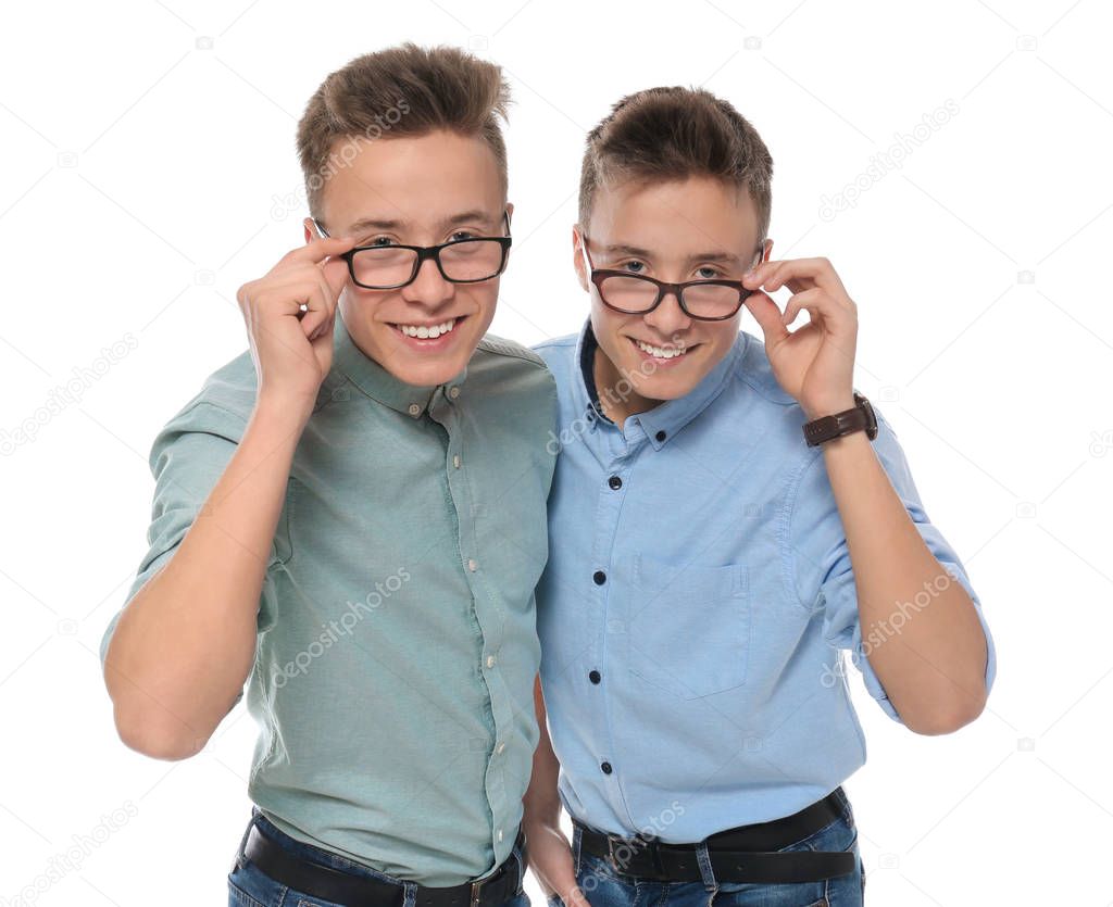 Teenage twin brothers with glasses on white background