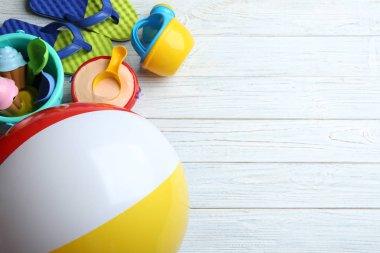 Ahşap arka plan üzerinde renkli plaj oyuncakları ile düz yatıyordu kompozisyon. Metin için alan