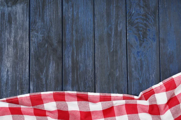 Koc piknik w kratkę na kolorowym drewnianym tle, widok z góry. Miejsce na tekst — Zdjęcie stockowe