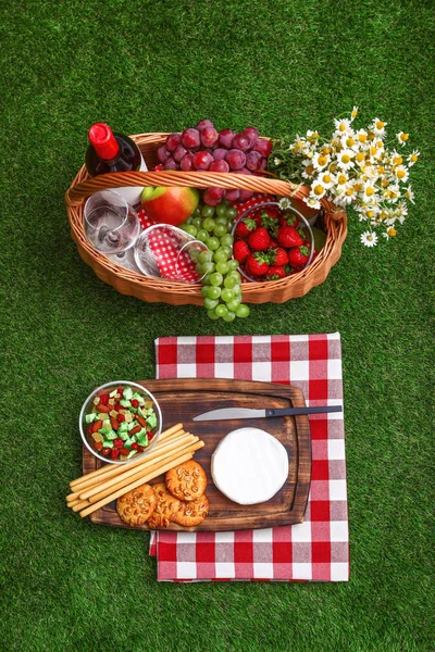 Composición plana con cesta de picnic, vino y productos sobre hierba — Foto de Stock