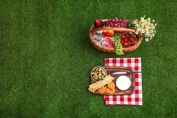 Flache Liegekomposition mit Picknickkorb, Wein und Produkten auf Gras, Platz für Text — Stockfoto
