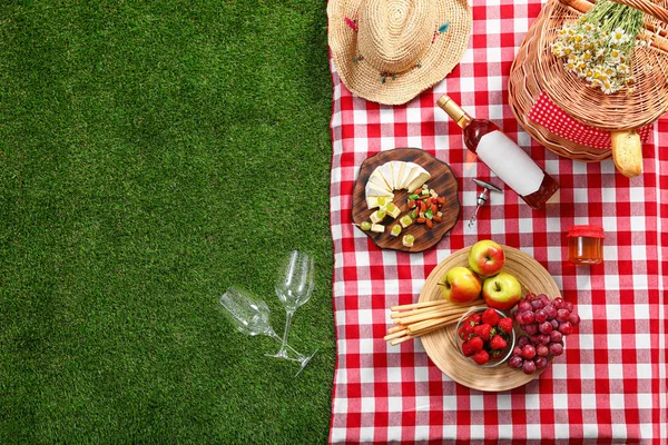 Flache Liegekomposition mit Picknickkorb und Produkten auf karierter Decke im Freien, Platz für Text — Stockfoto