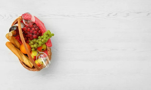 Picknickmand met producten en wijn op witte houten tafel, Top uitzicht. Ruimte voor tekst — Stockfoto
