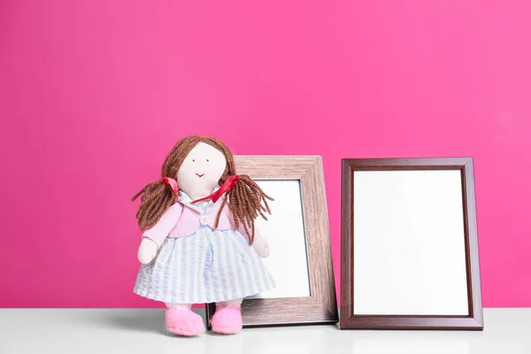 Fotoğraf çerçeveleri ve renkli arka plan, metin için alan karşı masada sevimli bebek. Çocuk odası elemanları — Stok fotoğraf