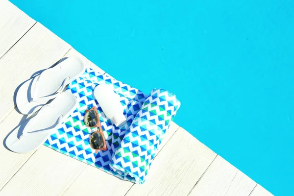 Accesorios de playa en la cubierta de madera cerca de la piscina, vista superior. Espacio para texto —  Fotos de Stock