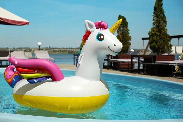 Anel inflável engraçado do unicórnio que flutua na piscina no dia ensolarado, ao ar livre — Fotografia de Stock