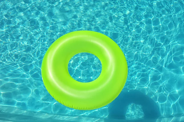 Bright inflatable ring floating in swimming pool on sunny day, above view — Stock Photo, Image