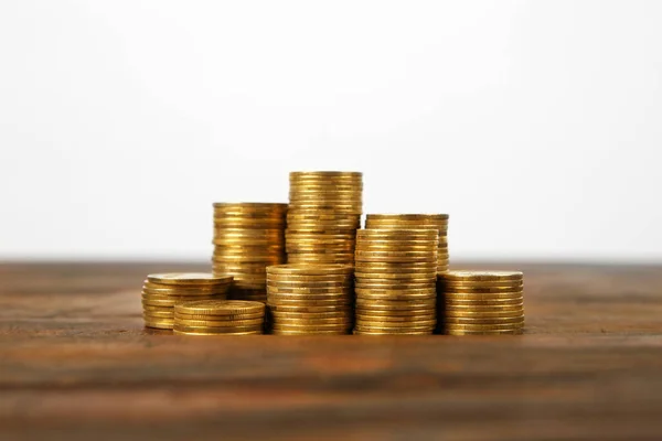Many stacks of coins on table against light background