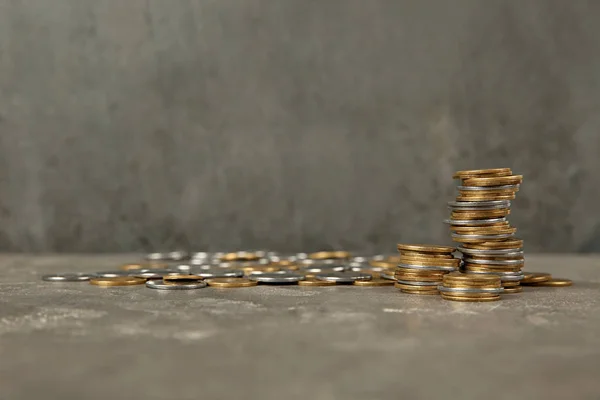 Muchas monedas en la mesa contra el fondo de color, espacio para el texto — Foto de Stock