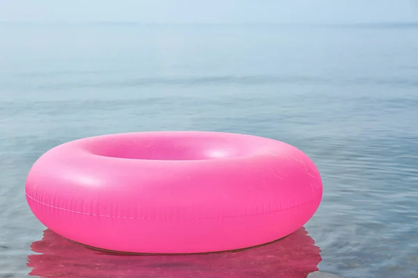 Яркое надувное кольцо, плавающее в морской воде. Летний отдых — стоковое фото