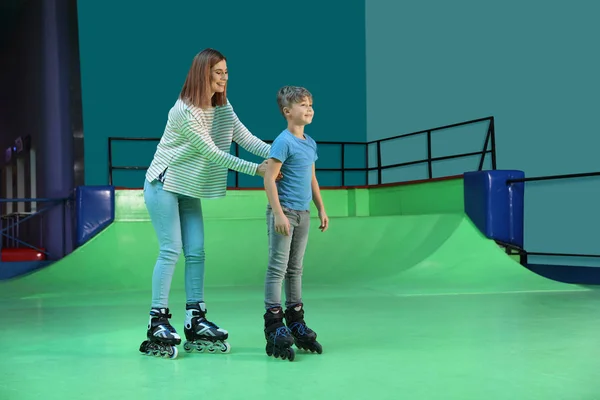 Woman teaching her son roller skating at rink. Space for text — 스톡 사진