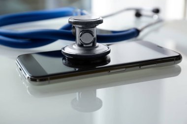 Akıllı telefon ve ışık masasında stetoskop, yakın çekim. Onarım hizmeti