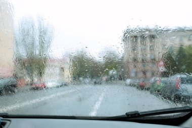 Blurred view of road through wet car window. Rainy weather clipart
