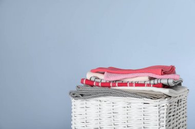 Renkli arka planda temiz havluları olan hasır çamaşır sepeti, yakın plan. Metin için boşluk
