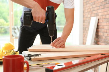 Elektrikli tornavidalar ile çalışan adam, kapalı