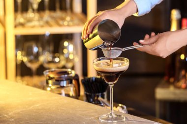 Bar tezgahında Espresso Martini hazırlayan kadın, yakın çekim. Alkol kokteyli