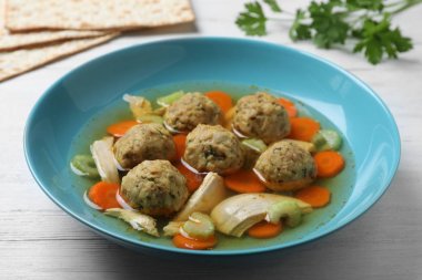 Beyaz ahşap masa üzerinde Yahudi matzoh topları çorba Kase