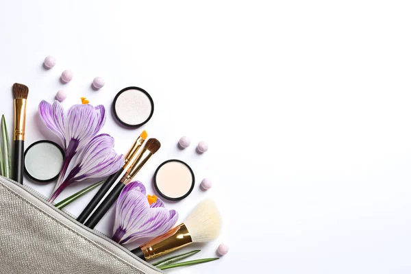 Makeup products, flowers and cosmetic bag on white background, top view — Stock Photo, Image