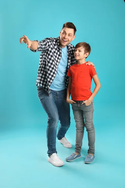 Retrato de pai e seu filho no fundo de cor — Fotografia de Stock