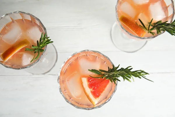 Vasos de cócteles de pomelo sobre mesa blanca, puesta plana —  Fotos de Stock