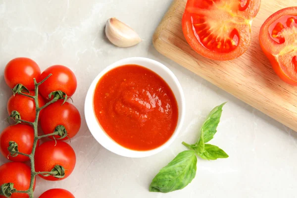 Platte lay compositie met kom saus en tomaten op Lichttafel — Stockfoto