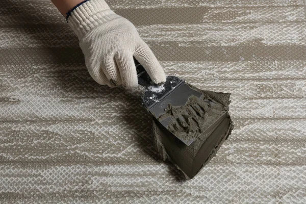 Trabalhador espalhando concreto na telha cerâmica com espátula, close-up — Fotografia de Stock