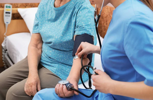 간호사는 병원 병동에서 고위 여성의 혈압을 측정, 클로즈업. 의료 지원 — 스톡 사진