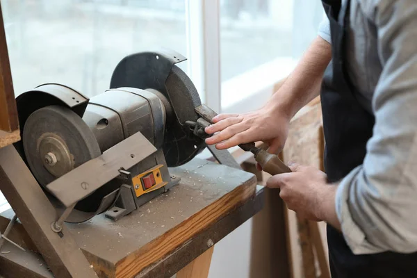 Working man using grinding machine at carpentry shop, closeup — Stock Photo, Image