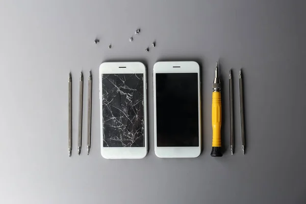 Επίπεδη σύνθεση με κινητά τηλέφωνα και εργαλεία σε γκρίζο φόντο, Χώρος για κείμενο. Επισκευή σέρβις — Φωτογραφία Αρχείου
