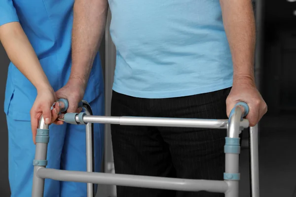 Infermiera che assiste il paziente anziano con walker in ospedale, primo piano — Foto Stock