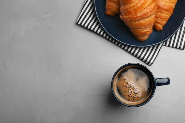 Flache Liegekomposition mit Kaffee und Croissants auf grauem Tisch, Platz für Text — Stockfoto
