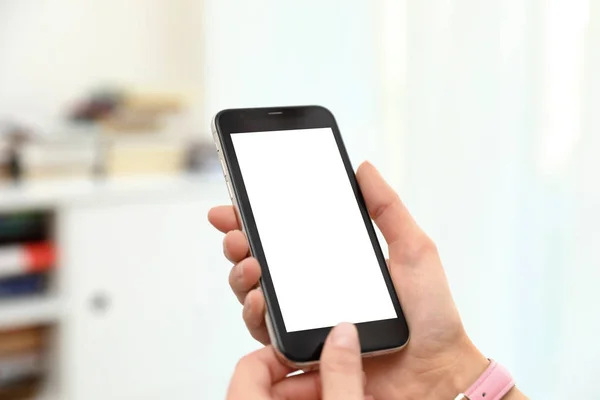 Woman Holding smartphone met leeg scherm binnenshuis, close-up van de handen. Ruimte voor tekst — Stockfoto