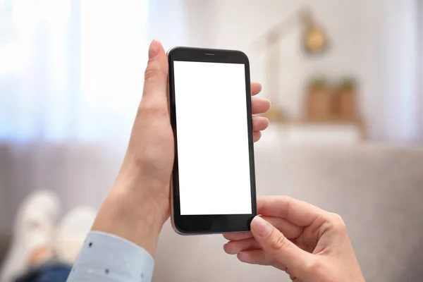 Woman Holding smartphone met leeg scherm binnenshuis, close-up van de handen. Ruimte voor tekst — Stockfoto