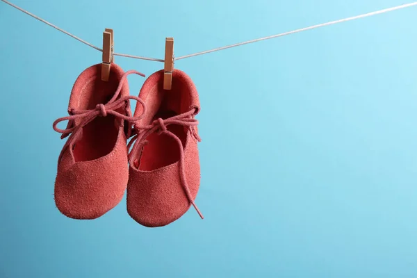 컬러 배경, 텍스트 공간에 대 한 세탁 라인에 매달려 귀여운 작은 신발. 베이비 액세서리 — 스톡 사진
