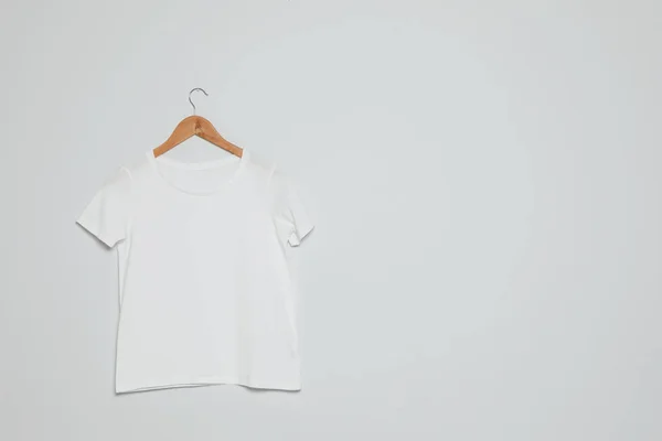 Hanger with blank t-shirt on gray background. Mock up for design — Stock Photo, Image