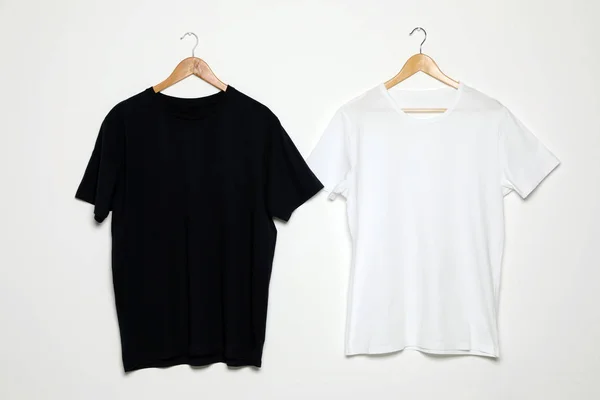 Hangers met blanco t-shirts op witte achtergrond. Mock up voorontwerp — Stockfoto