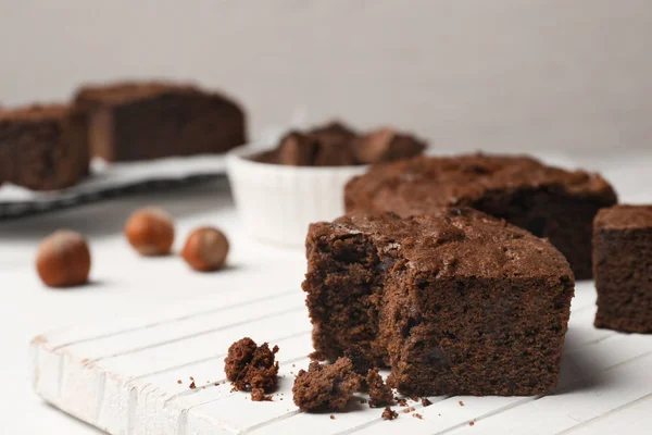 Placa com brownies frescos na mesa contra fundo claro, espaço para texto. Deliciosa torta de chocolate — Fotografia de Stock