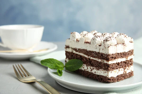 Bolo Tiramisu com copo na mesa contra fundo de cor, espaço para texto — Fotografia de Stock