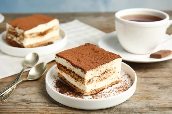 Samenstelling met tiramisu taarten en thee op tafel — Stockfoto