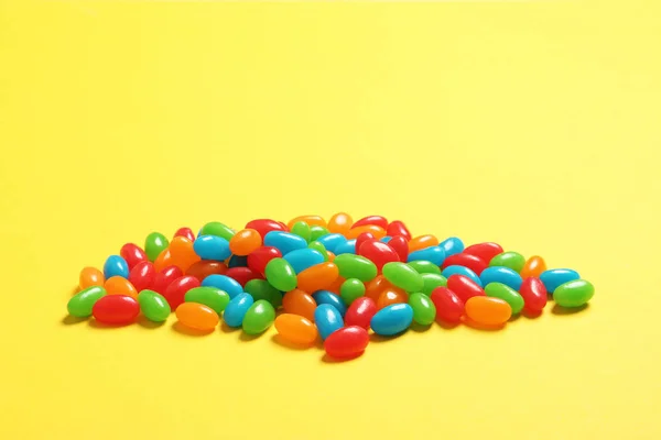 Delicious bright jelly beans on color background — Stok Foto