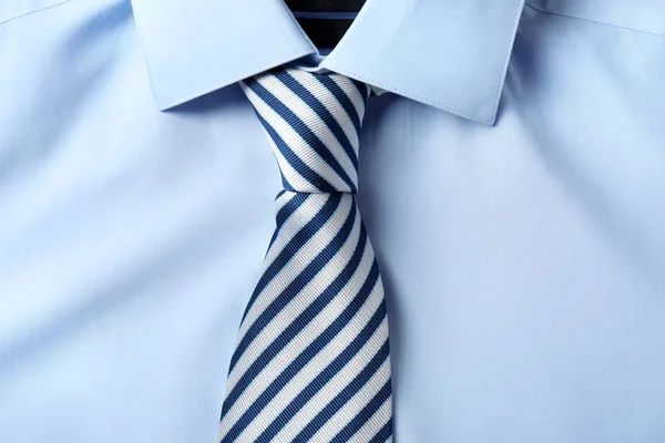 Striped male necktie on blue shirt, closeup — Stock Photo, Image