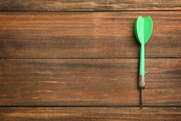 Flecha dardo sobre fondo de madera, vista superior. Espacio para texto — Foto de Stock