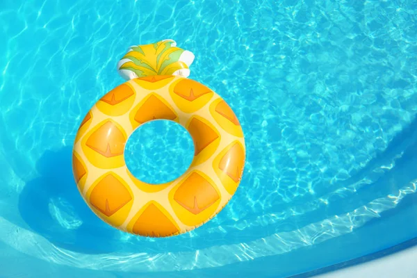 Anel inflável brilhante do abacaxi que flutua na piscina no dia ensolarado, acima da vista. Espaço para texto — Fotografia de Stock