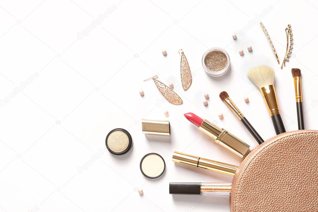 Cosmetic bag and different luxury makeup products on white background, top view