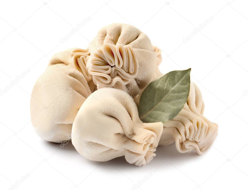Pile of raw dumplings with bay leaf on white background