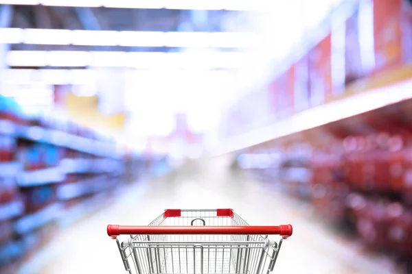 Размытый вид супермаркета и пустой корзины — стоковое фото