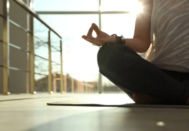 Genç kadın güneş aydınlatmalı odada Yoga pratik, metin için boşluk ile çekim